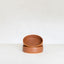 Two terracotta bowls stacked on a white surface with a white background