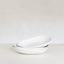 Stack of white ceramic bowls on a light gray background