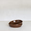Two brown ceramic bowls stacked on a white surface with a white background