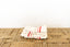 Stack of white towels with red stripes on a woven mat