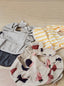 An assortment of Trend{ING}s playful baby bibs scattered on a table