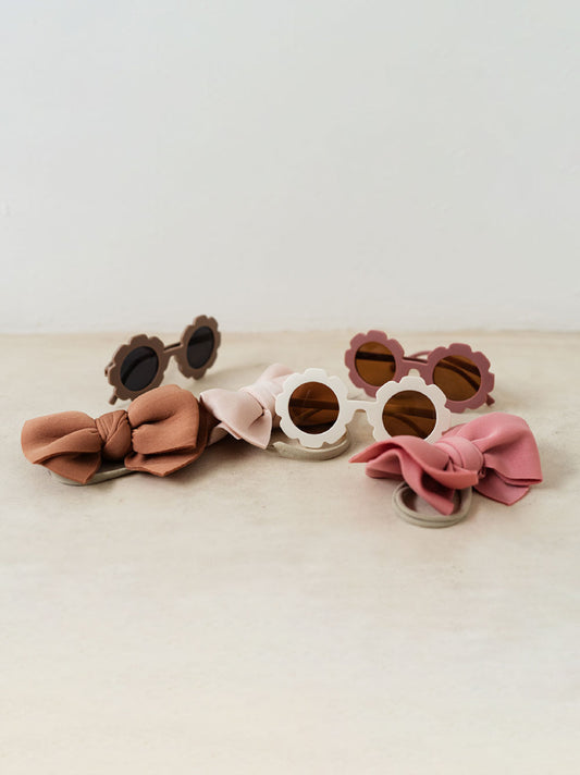 Trend{ING}s Baby Sunny Sunglasses Set with hair bows next to them