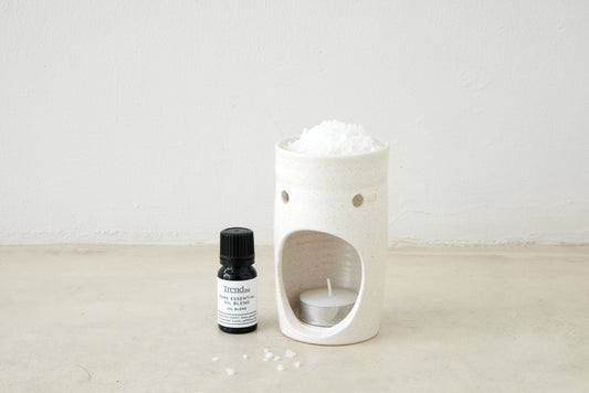 Trend{ING}s Ceramic Candle Oil Burner with a tealight candle and pure essential oil blend  next to each other