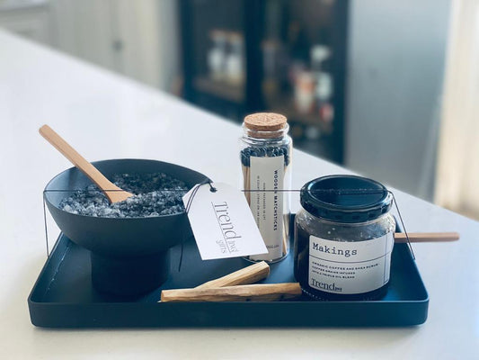 Trend-ing's Calm & Zen Relaxing Self Care Gift Box, featuring a black ceramic footed bowl containing Activated charcoal bath salts, wooden matches & scrub in a tray