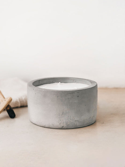 Trend{ING}s Raw Cement Candle with a towel and palo santo sticks beside it