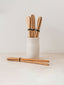 Mixture of Trend{ING}s Ethnic wooden spoons in a jar and laying on the counter beside it