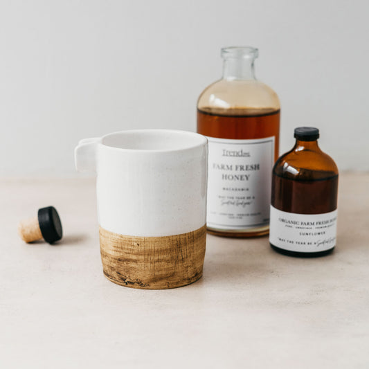 Trend{ING}s Honey Jug in Natural wooden bottom, with two amber jars of honey in the background