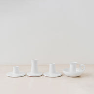 Trend{ING}s White gloss ceramic candle holders standing together on a table with 3 different sizes 