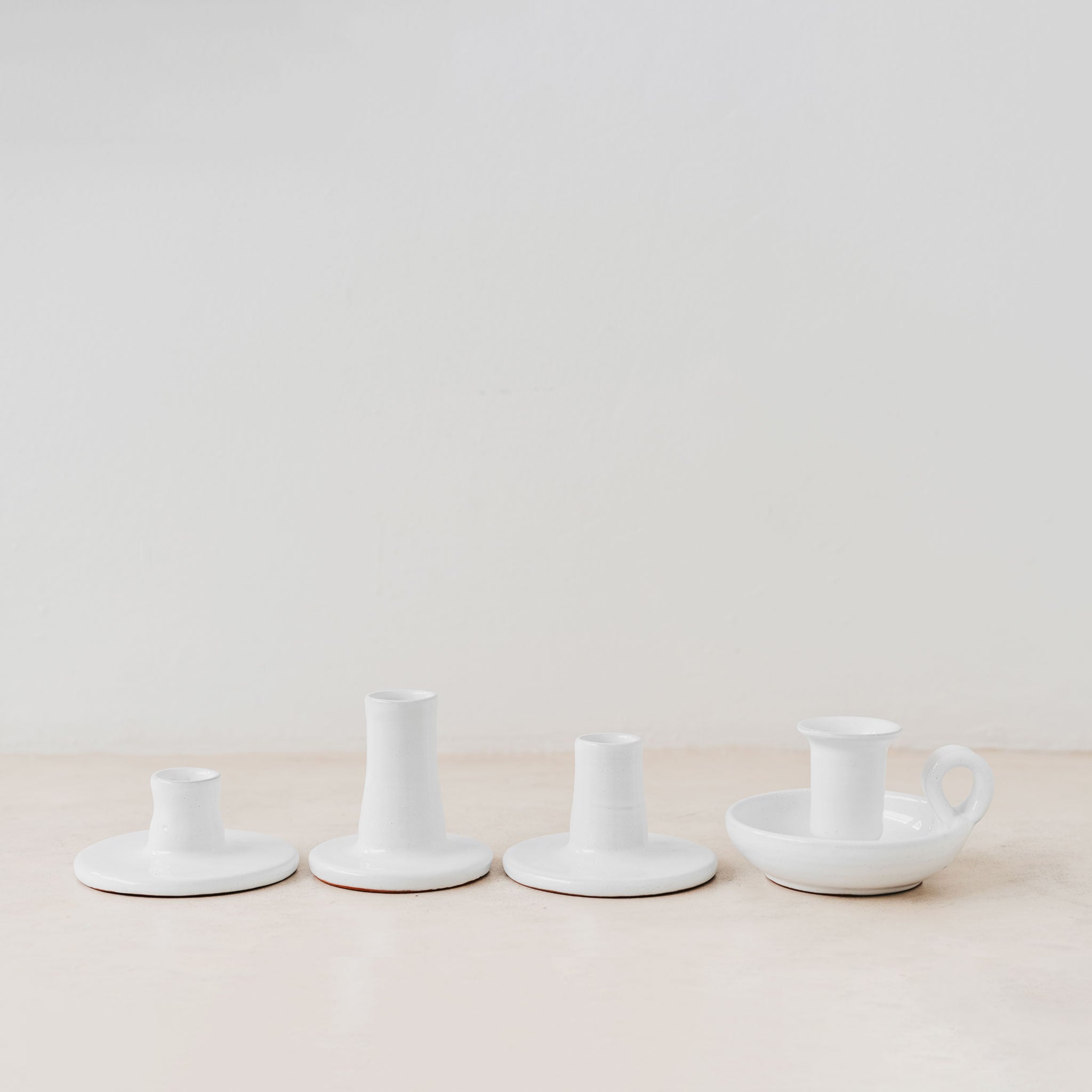 Trend{ING}s White gloss ceramic candle holders standing together on a table with 3 different sizes 