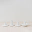 Trend{ING}s White gloss ceramic candle holders standing together on a table with 3 different sizes 