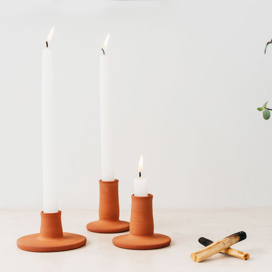 Trend{ING}s Natural terracotta ceramic candle holder - all 3 sizes standing together with lit candles inside them