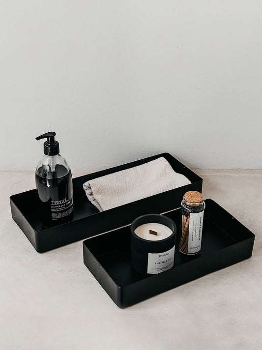Trend{ING}s deep steel storage tray, small and large size together in black, filled with bathroom items, like our charcoal handwash, towel, wooden wick candle and long luxury matches