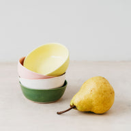 Trend{ING}s Mini Clay Bowls stacked on top of one another with a pear next to it