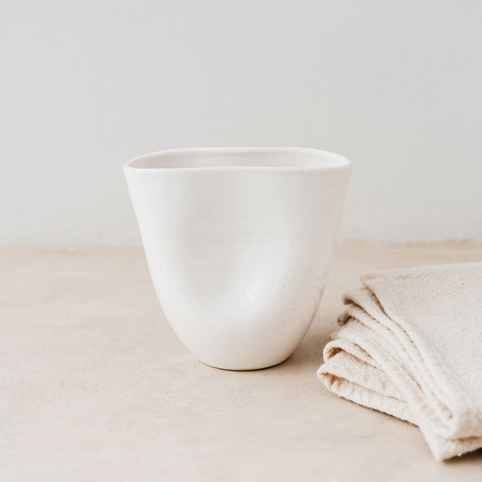 Trend{ING}s Ritual Ceramic Cup in white next to linen placemats