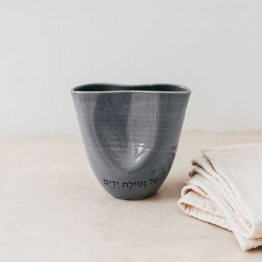 Trend{ING}s Ritual Ceramic Cup in charcoal with a blessing next to linen placemats