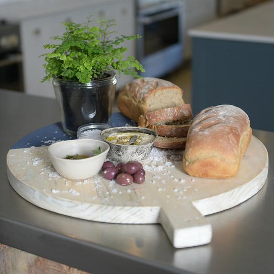 Trend-ings thick round wooden serving board with handle (45cm), with breads, olives, hummus dip and plant on the board